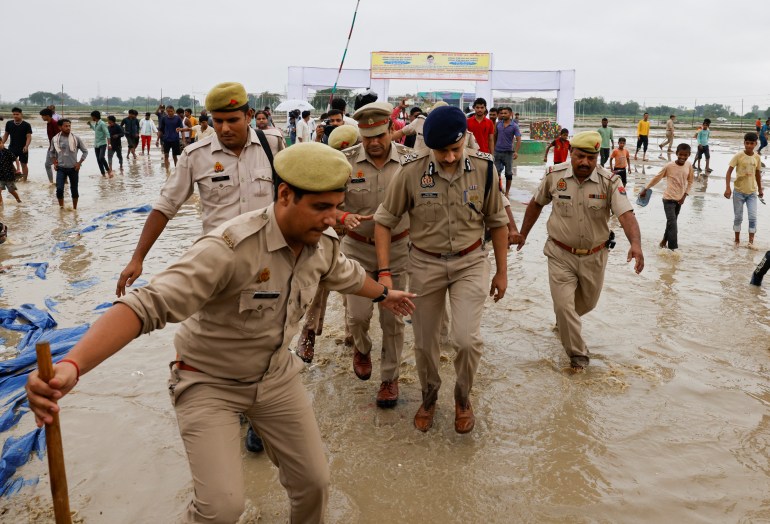 Police officers walk at the site where believers had gathered for a Hindu religious congregation 