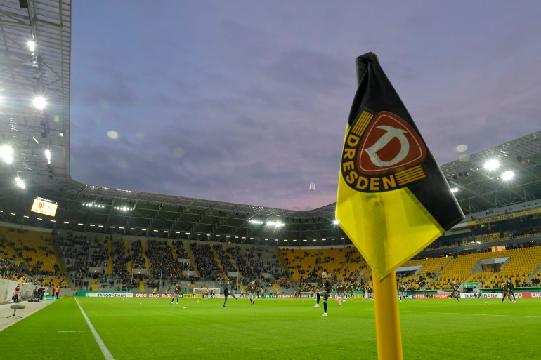 Corner flag pitched in front of football stadium.