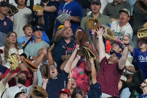 Fans reach for a home run ball during the All-Star...