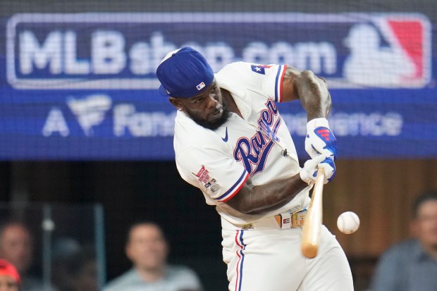 The Texas Rangers’ Adolis Garcia connects during the MLB baseball...