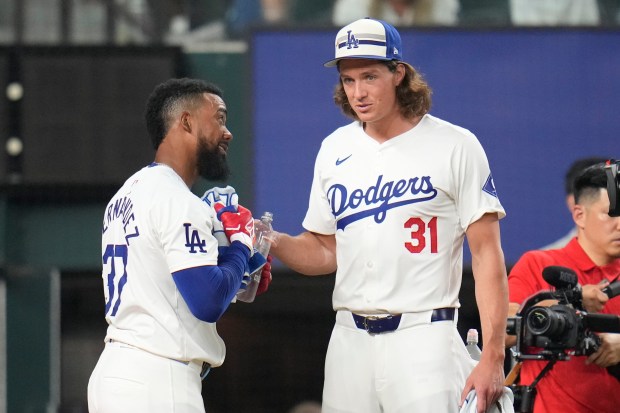 Dodgers outfielder Teoscar Hernández, left, talks to teammate, pitcher Tyler...