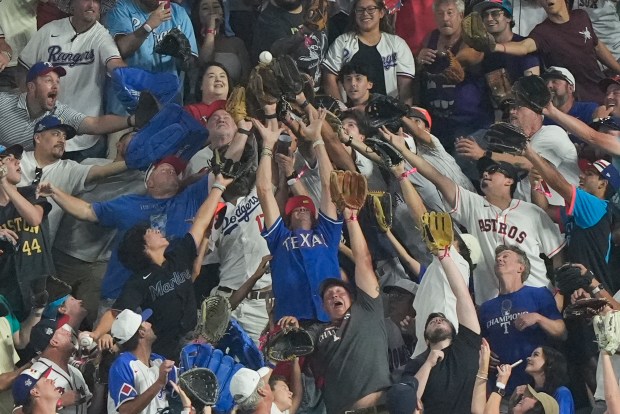 Fans reach for a home run ball during the All-Star...