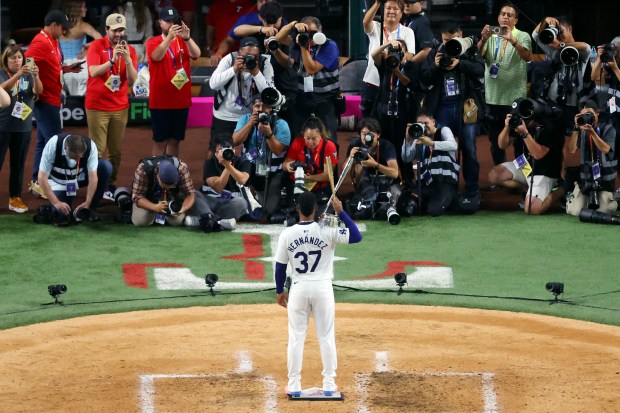 Dodgers outfielder Teoscar Hernández poses with the trophy after winning...