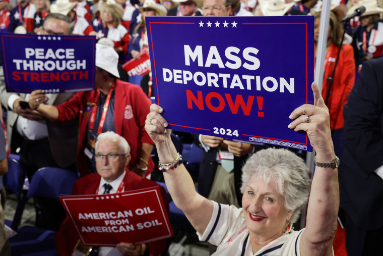 People hold "Mass Deportation Now!" signs at the Republican National Convention in Milwaukee