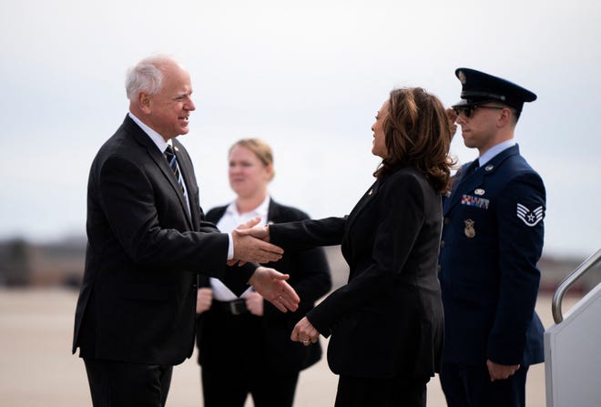 (L-R) Minnesota Governor Tim Walz greets US Vice President Kamala Harris as she arrives at the Minneapolis-St. Paul International Airport in Saint Paul, Minnesota on March 14, 2024.