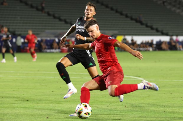 AFC Bournemouth defender Milos Kerkez, front, kicks the ball while...