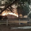 A fast-moving wildfire near the Oregon-Idaho border moves toward a home on Rye Valley Lane in Huntington, Ore., on Wednesday afternoon.