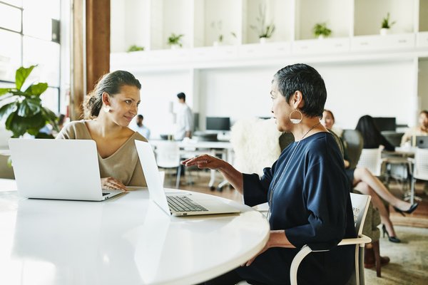 Businesspeople meeting in large open office area.