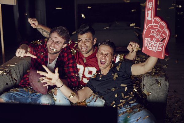 Men watching football on a television.