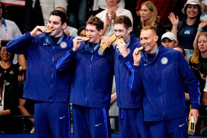 United States teammates Jack Alexy, Chris Guiliano, Hunter Armstrong and Caeleb Dressel line up on the podium for the men’s 4 x 100-meter freestyle relay medal ceremony on Saturday.