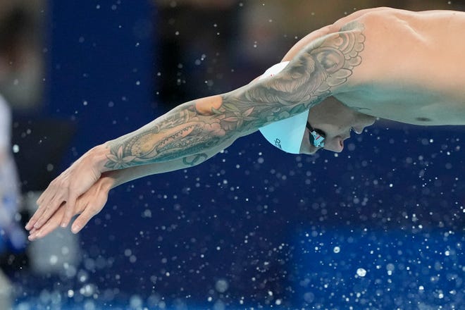 Caeleb Dressel plunges into the water during the preliminaries of the men's 4x100-meter freestyle swimming relay at Saturday's Olympics in Paris.