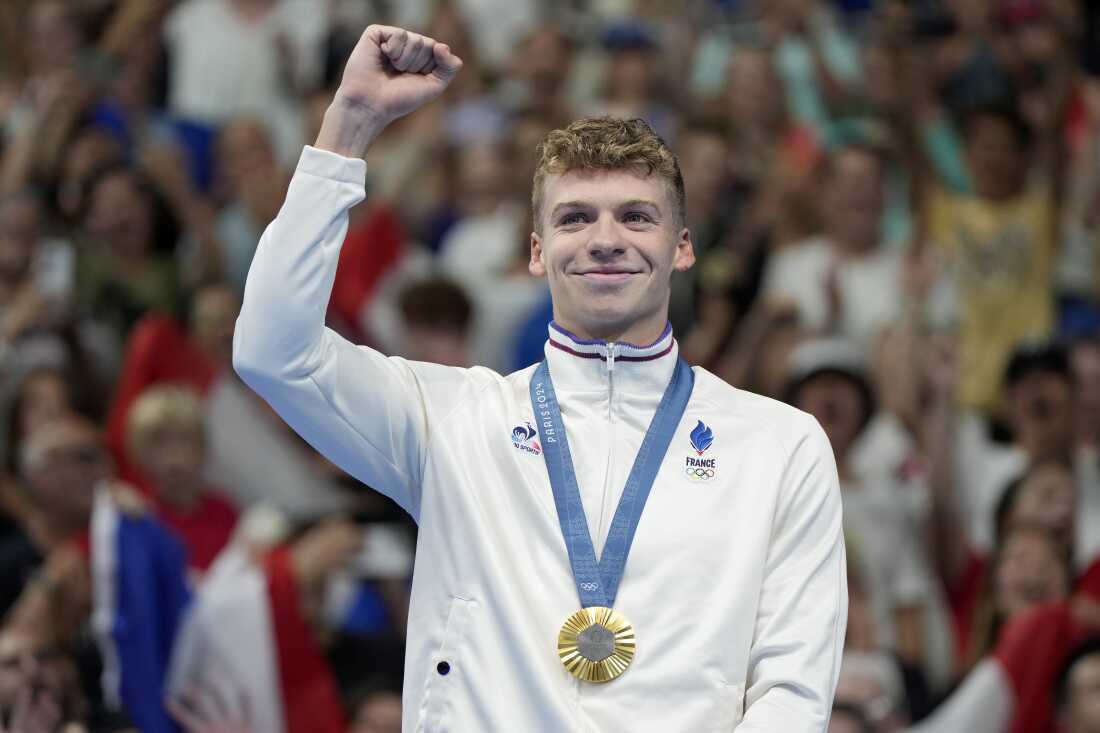 Leon Marchand, of France, celebrates after receiving his first gold medal for in the men's 400-meter individual medley final at the 2024 Summer Olympics, Sunday, July 28, 2024, in Nanterre, France. (AP Photo/Matthias Schrader)