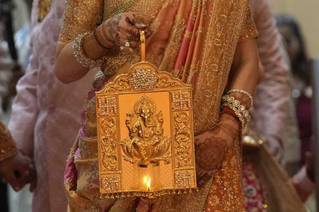 Nita Ambani, wife of Asia's richest man, Mukesh Ambani, arrives holding a lamp with an image of elephant-headed Hindu god Ganesha, for the wedding of their youngest son, Anant Ambani in Mumbai on Friday.