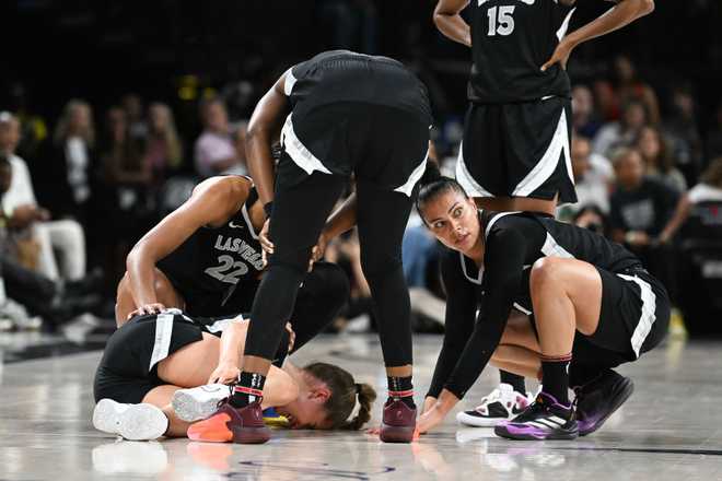 LAS VEGAS, NEVADA - JULY 16: A&apos;ja Wilson #22, Chelsea Gray #12 and Alysha Clark #7 rush to Kate Martin #20 of the Las Vegas Aces after being injured against the Chicago Sky in the first half of their game at Michelob ULTRA Arena on July 16, 2024 in Las Vegas, Nevada. The Sky defeated the Aces 93-85. (Photo by Candice Ward/Getty Images)