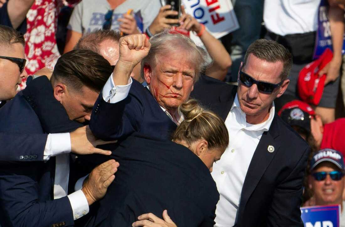 Republican candidate Donald Trump is surrounded by Secret Service agents following an attempted assassination attempt in in Butler, Pa., on July 13. The head of the Secret Service will appear before lawmakers Monday to discuss the agency's actions before, during and after the incident.