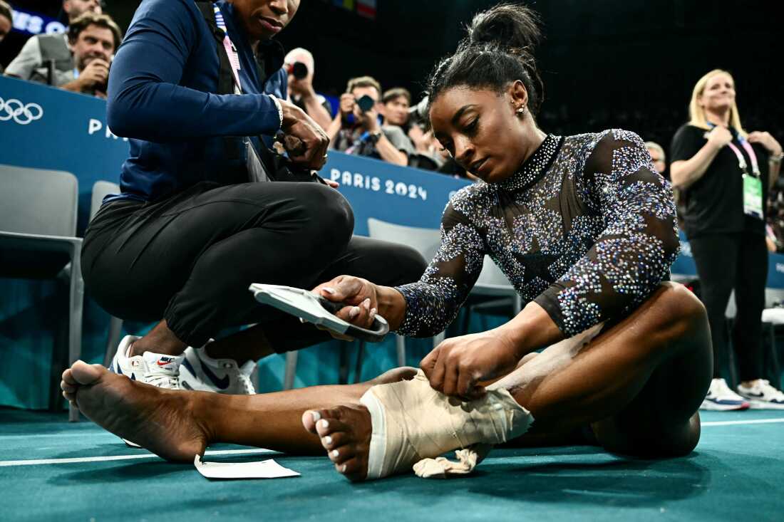 The U.S. gymnast Simone Biles appeared to hurt her lower left leg during a warmup on Sunday, but she finished the remaining events after wrapping her ankle with thick athletic tape.