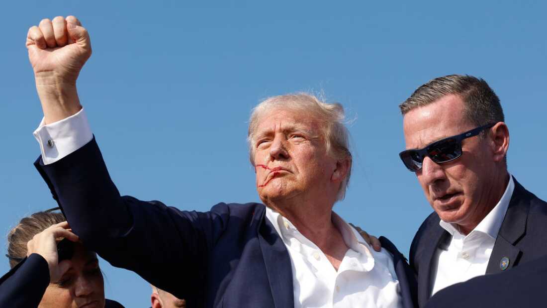 Former President Trump pumps his fist as he is rushed offstage during a rally on July 13, 2024, in Butler, Pa.