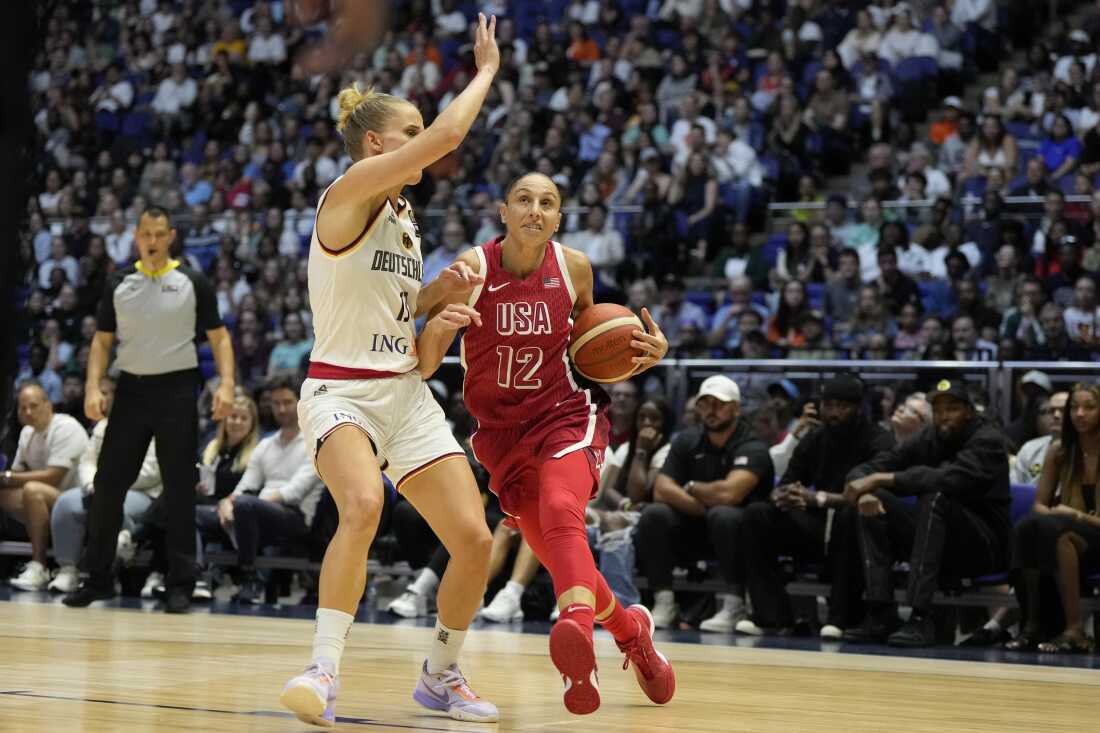 United States' Diana Taurasi (right) drives around Germany's Leonie Fiebich during a women's exhibition basketball game between the United States and Germany in London on July 23, 2024.