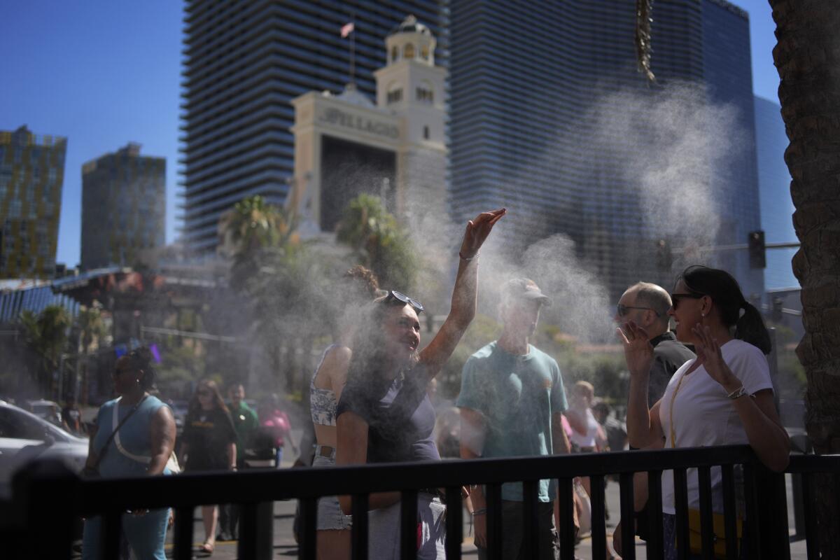 People cool off in misters along the Las Vegas Strip on July 7.