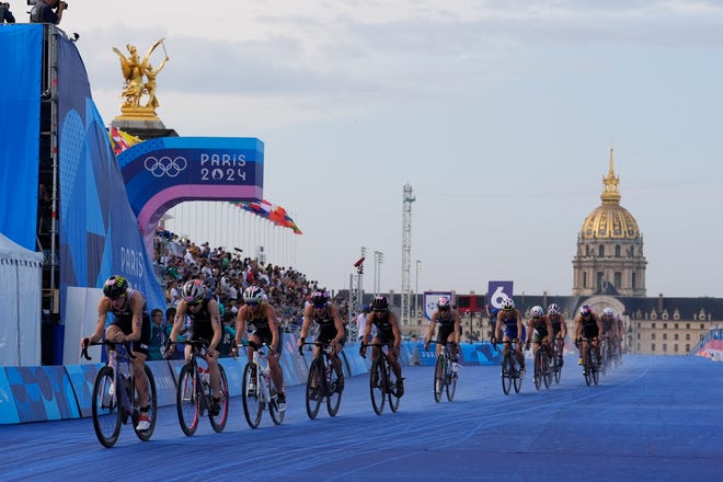 Taylor Knibb (USA) leads a group of riders across the Pont Alexandre III with Les Invalides in the background.