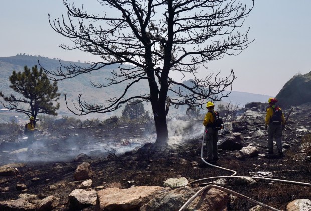 Firefighters douse flames with water near a home being threatened by the Stone Canyon Fire near Lyons on Wednesday, July 31, 2024. (Photo by Zachary Spindler-Krage/The Denver Post)