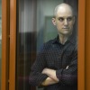 Wall Street Journal reporter Evan Gershkovich stands in a glass cage in a courtroom in Yekaterinburg, Russia, Wed., June 26, 2024.