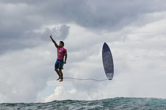 Brazilian surfer Gabriel Medina leaps from his surfboard and raises his finger in the air as he celebrates <a href=