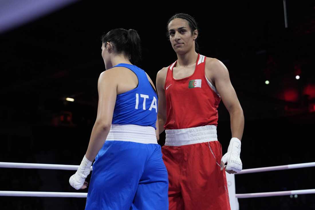 Algeria's Imane Khelif, right, walks beside Italy's Angela Carini in the boxing ring after winning their match.