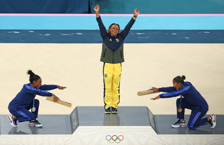 Gold medalist Rebeca Andrade, center, silver medalist Simone Biles, left, and bronze medalist Jordan Chiles