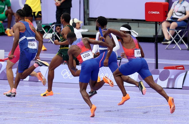 The USA's Christian Coleman and Kenneth Bednarek miss their baton handoff in the men's 4x100m final during the Paris Olympics at Stade de France.