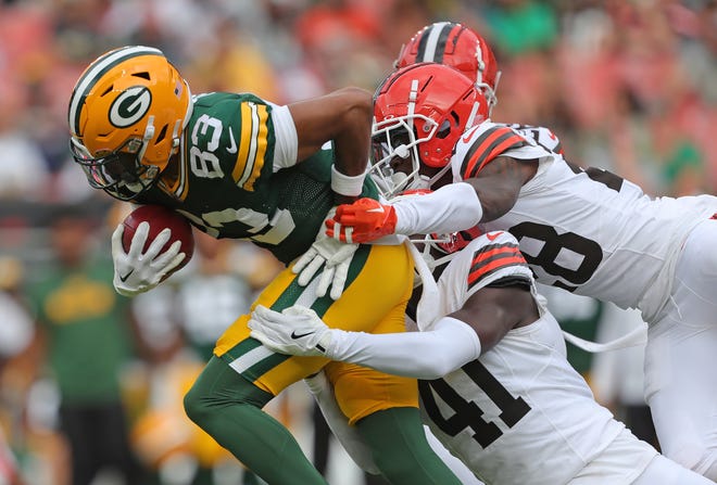 Cleveland Browns tight end Zaire Mitchell-Paden (83) tries to slip away from Cleveland Browns safety Chris Edmonds (41) and Cleveland Browns cornerback Justin Hardee Sr. (28) during the second half of an NFL preseason football game at Cleveland Browns Stadium, Saturday, Aug. 10, 2024, in Cleveland, Ohio.