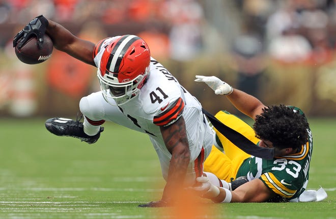 Cleveland Browns running back John Kelly Jr. (41) reaches for more yards as he is tripped up by Green Bay Packers safety Evan Williams (33) during the first half of an NFL preseason football game at Cleveland Browns Stadium, Saturday, Aug. 10, 2024, in Cleveland, Ohio.