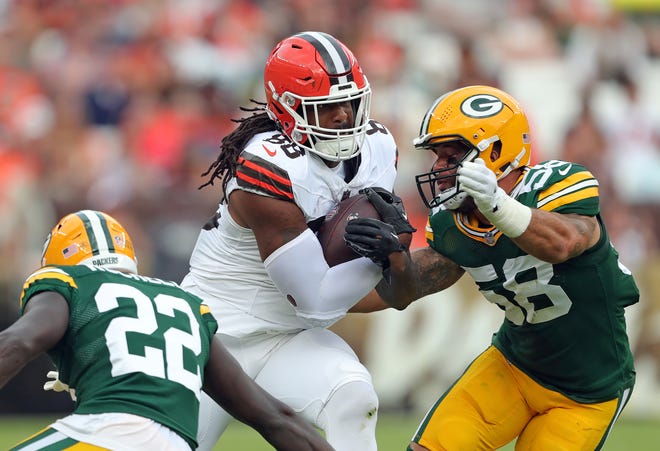 Cleveland Browns tight end Jordan Akins (88) runs for yards after a catch between Green Bay Packers cornerback Robert Rochell (22) and Green Bay Packers linebacker Isaiah McDuffie (58) during the first half of an NFL preseason football game at Cleveland Browns Stadium, Saturday, Aug. 10, 2024, in Cleveland, Ohio.