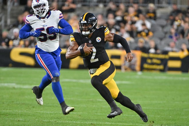 Pittsburgh Steelers quarterback Justin Fields (2) runs away from Buffalo Bills defensive end Kingsley Jonathan (59) during the second quarter at Acrisure Stadium.