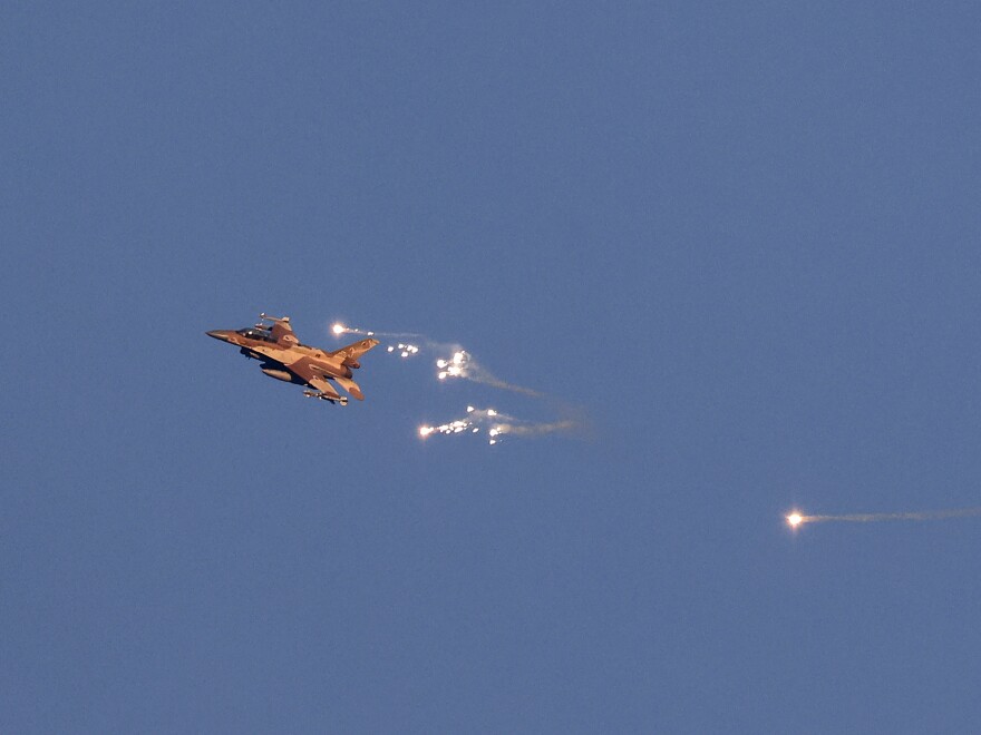 This photo taken from a position in northern Israel shows an Israeli Air Force fighter jet firing flares as it flies to intercept a hostile aircraft that launched from Lebanon over the border area with south Lebanon on Sunday. 