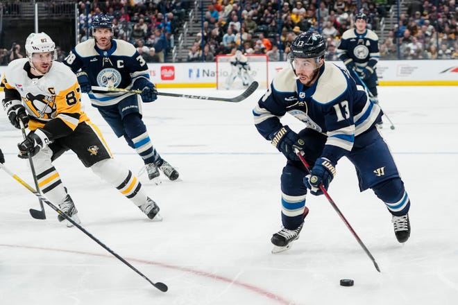 Nov 14, 2023; Columbus, Ohio, USA; Columbus Blue Jackets left wing Johnny Gaudreau (13) brings the puck up ice past Pittsburgh Penguins center Sidney Crosby (87) during the third period of the NHL hockey game at Nationwide Arena. The Blue Jackets lost 5-3.