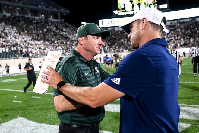 Michigan State's head coach Jonathan Smith, left shakes hands with Florida Atlantic's head coach Tom Herman after the game on Friday, Aug. 30, 2024, at Spartan Stadium in East Lansing.