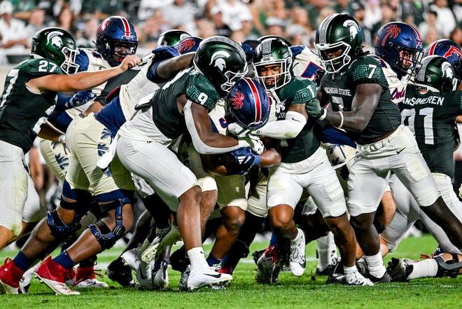 Michigan State's JJalen Thompson, left, and Nikai Martinez tackle Florida Atlantic's Cam Fancher during the fourth quarter on Friday, Aug. 30, 2024, at Spartan Stadium in East Lansing.