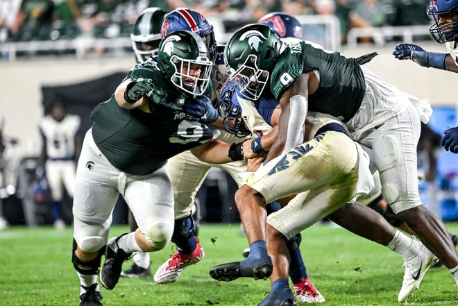 Michigan State's Jalen Thompson, right, tackles Florida Atlantic's Cam Fancher during the fourth quarter on Friday, Aug. 30, 2024, at Spartan Stadium in East Lansing.