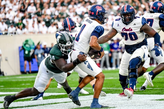 Michigan State's D'Quan Douse, left, sacks Florida Atlantic's Cam Fancher for a safety during the first quarter on Friday, Aug. 30, 2024, at Spartan Stadium in East Lansing.