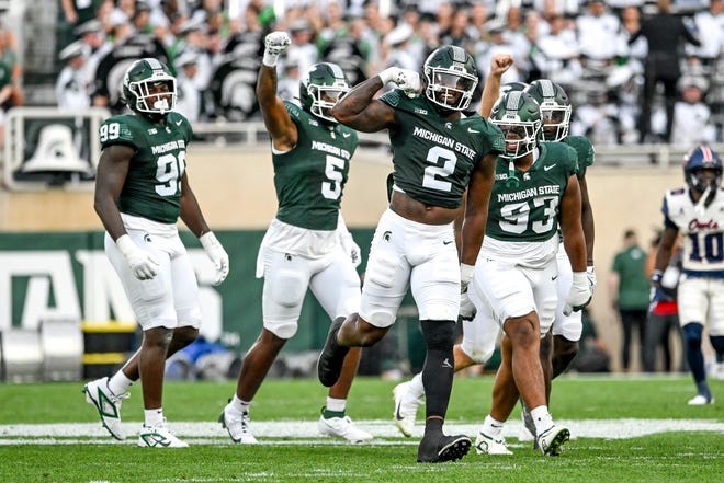 Michigan State's Khris Bogle, center, celebrates his stop against Florida Atlantic during the first quarter on Friday, Aug. 30, 2024, at Spartan Stadium in East Lansing.