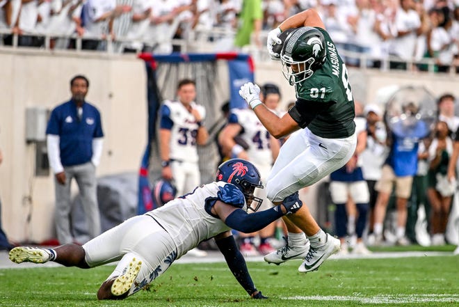 Michigan State's Michael Masunas, right, catches a pass as Florida Atlantic's Desmond Tisdol closes in during the first quarter on Friday, Aug. 30, 2024, at Spartan Stadium in East Lansing.