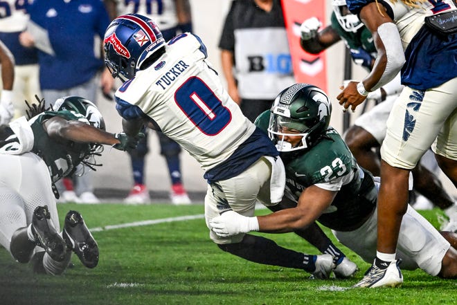 Michigan State's Darius Snow, right, tackles Florida Atlantic's Milan Tucker during the second quarter on Friday, Aug. 30, 2024, at Spartan Stadium in East Lansing.