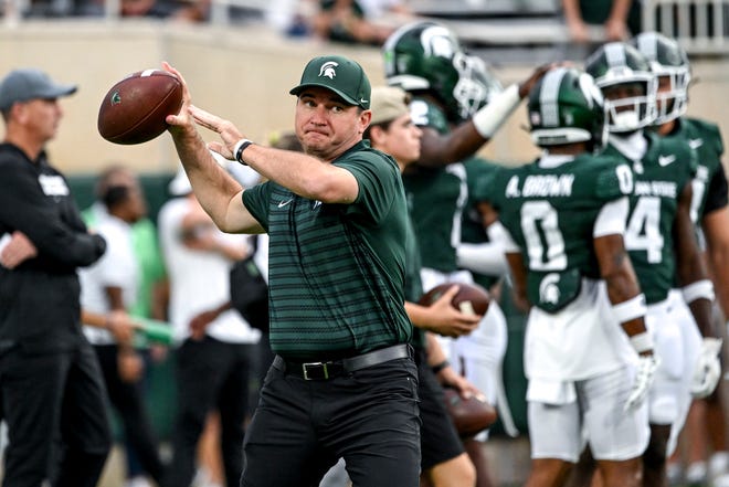 Michigan State's head coach Jonathan Smith throws a pass during warmups before the game against Florida Atlantic on Friday, Aug. 30, 2024, at Spartan Stadium in East Lansing.