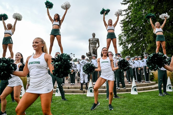 Michigan State's cheer team performs at the Sparty statue before the game against Florida Atlantic on Friday, Aug. 30, 2024, outside Spartan Stadium in East Lansing.