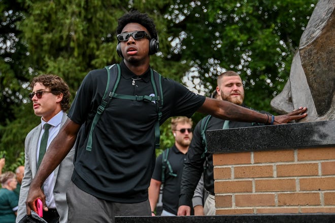 Michigan State's Aidan Chiles touches the foot of the Sparty statue before the game against Florida Atlantic on Friday, Aug. 30, 2024, outside Spartan Stadium in East Lansing.