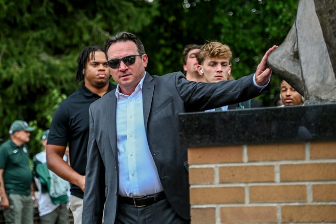 Michigan State's head coach Jonathan Smith touches the foot of the Sparty statue before the game against Florida Atlantic on Friday, Aug. 30, 2024, outside Spartan Stadium in East Lansing.