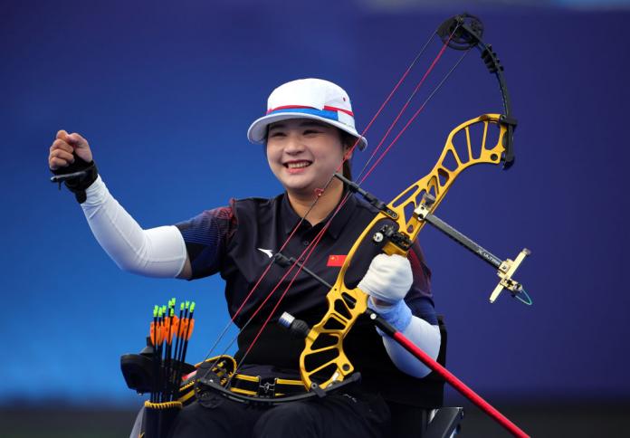 Chinese archer Chen Minyi lifts her bow, which is red and yellow, in celebration