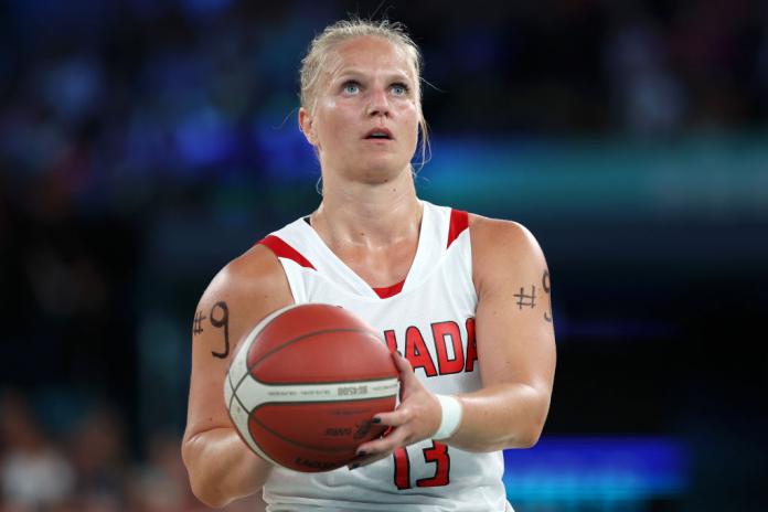 Canadian wheelchair basketball player Kady Dandeneau holds the ball as she prepares to shoot