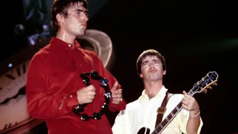 Getty Liam and Noel Gallagher rocking out on stage in the 1990s